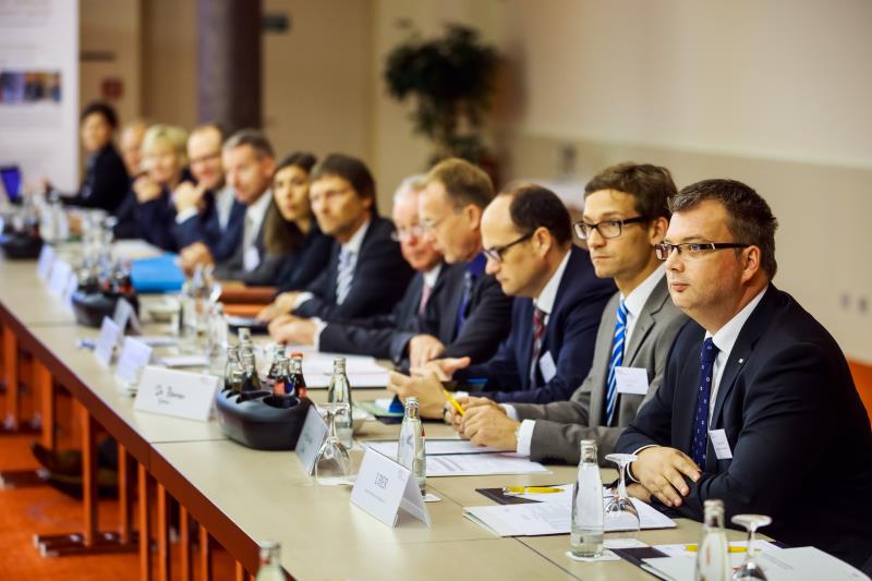 Ein halbrunder Tisch mit Vertretern aus Politik, Wirtschaft und Verbänden